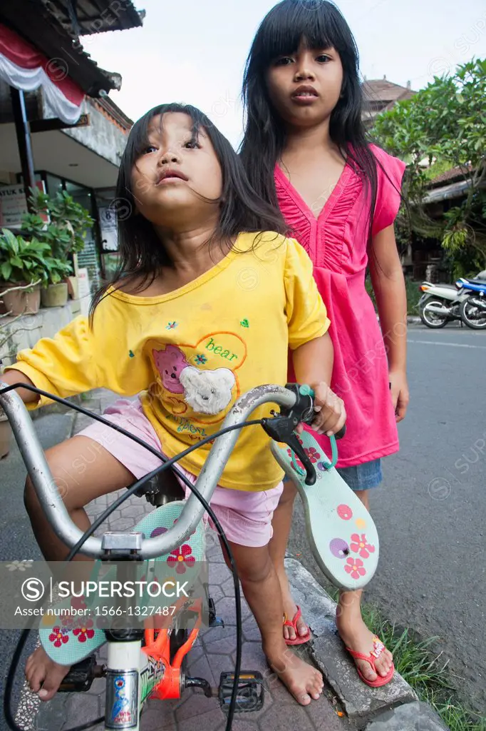 Portrait of two girls in the street, Ubud, Bali, Indonesia.