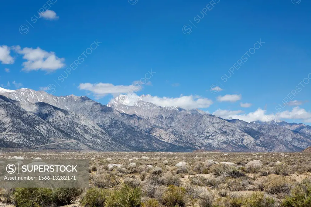 The Sierra Nevada Mountain Range towers above the desert valley floor forming a natural barrier in the Owens Valley in Central California.