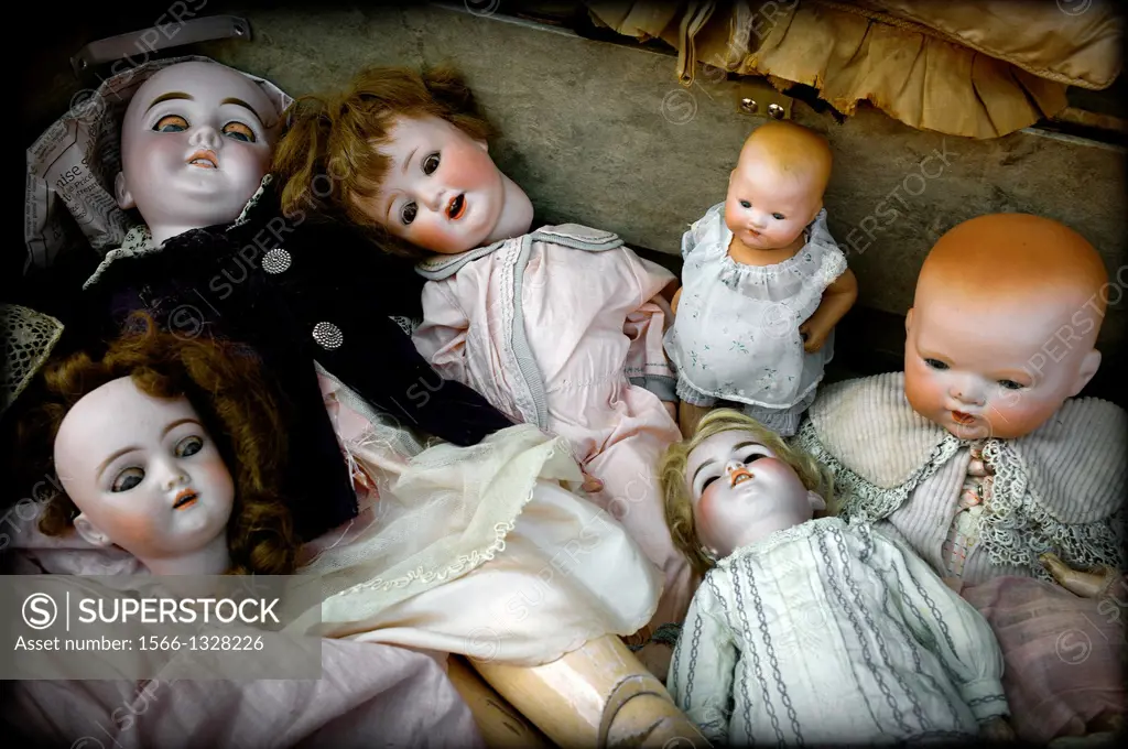 group of antique dolls in Puces de Saint-Ouen, antiques market in Paris, France