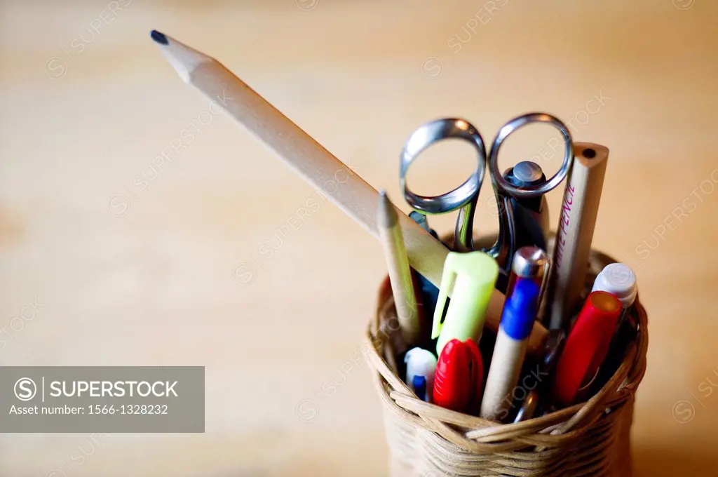 Basket with pens, pencils, and scissors.