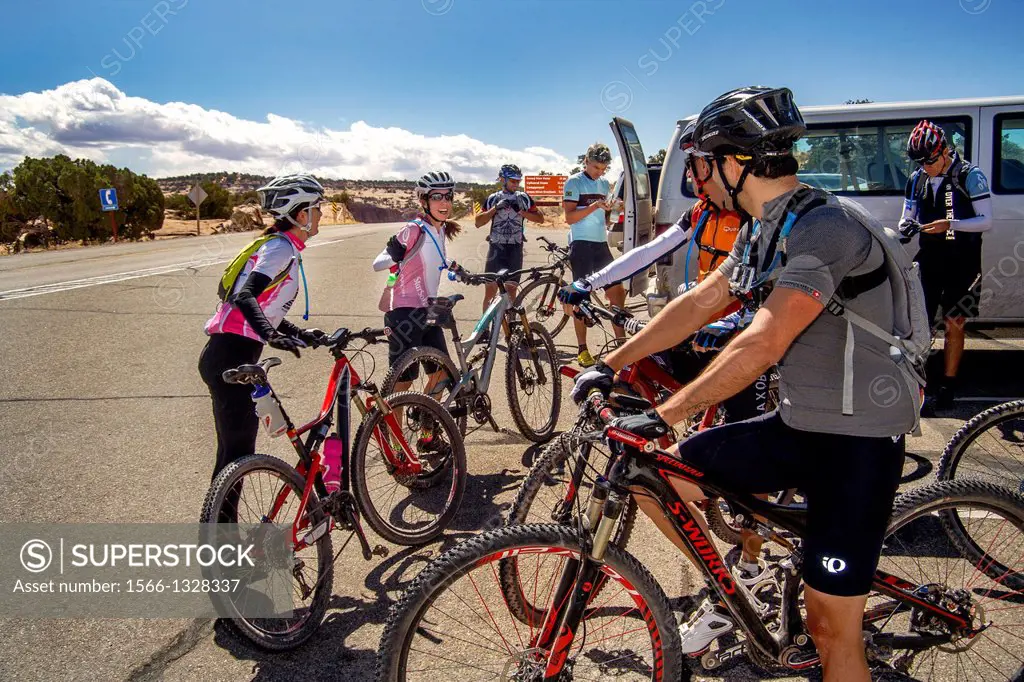 Wearing helmets and specialized clothing, an Italian mountain bicycle club greets two women members as they dismount in Canyonlands National Park, Uta...