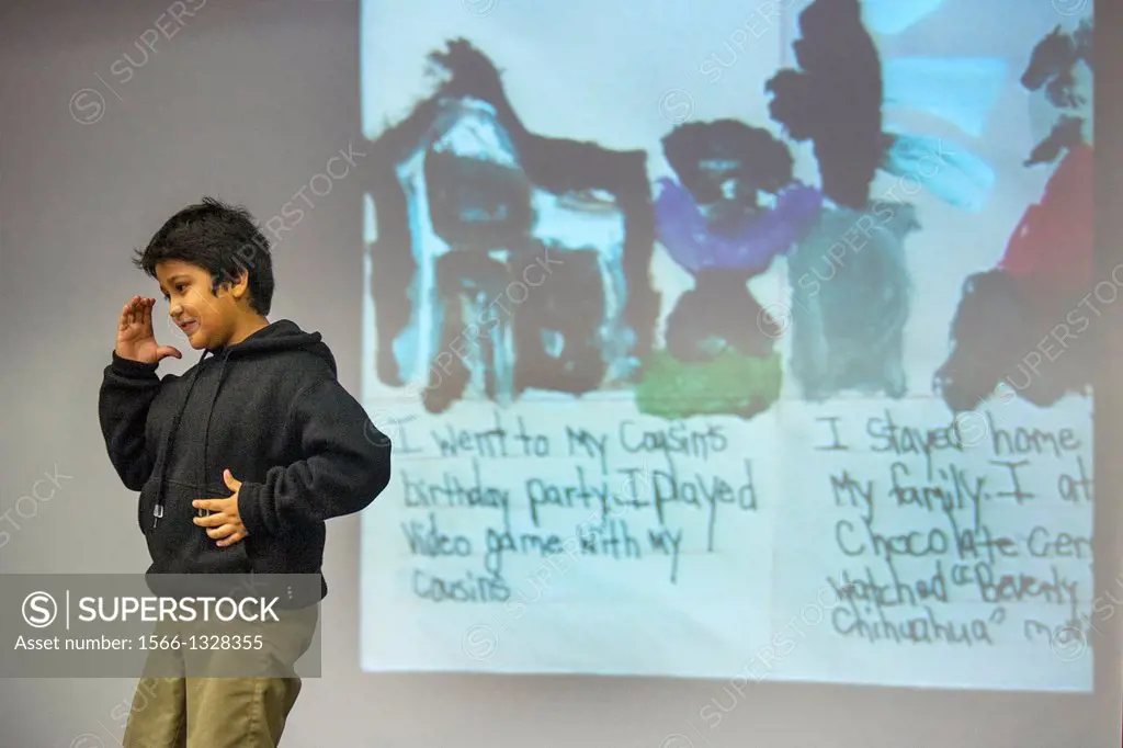 A deaf child uses sign language to ""read"" the composition he has written projected on the screen behind him at the California School for the Deaf in...