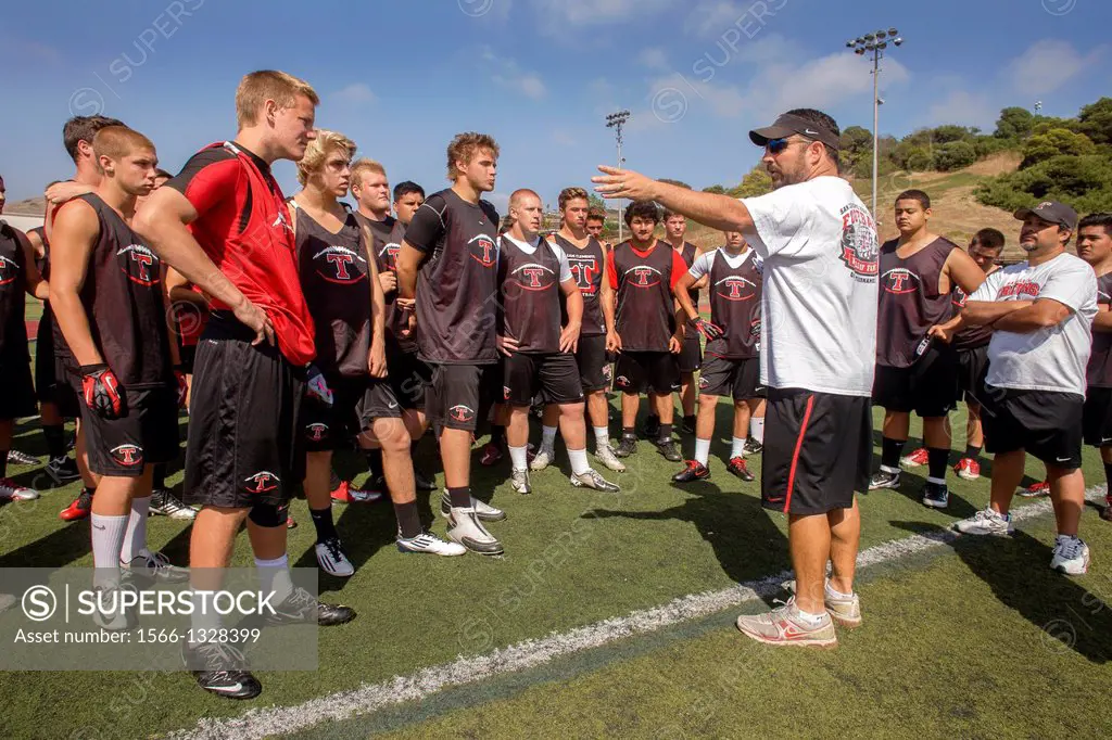 A high school coach gives a pep talk to his new team during spring football practice in San Clemente, CA.