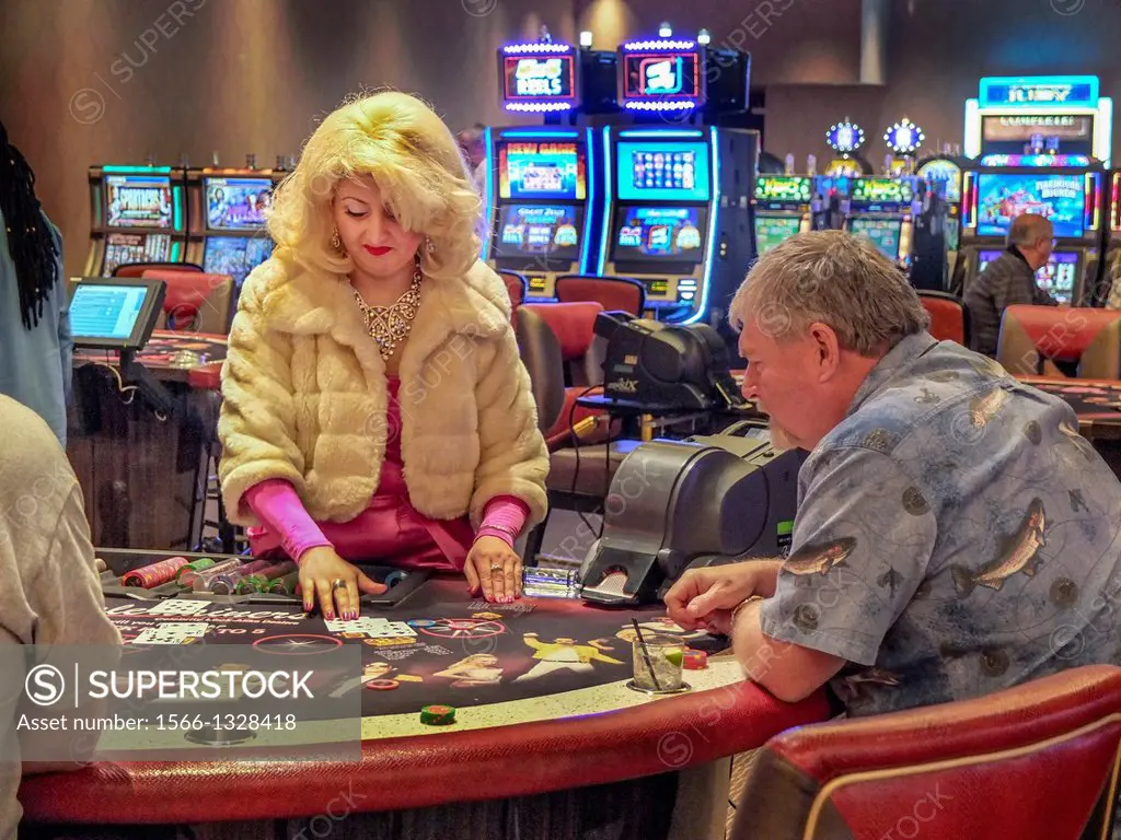 Dressed in a gaudy outfit, a casino Punto Banco barrarat croupier conducts a game in Las Vegas, NV. Note ""shoe"" for dealing cards on table. "" In Pu...