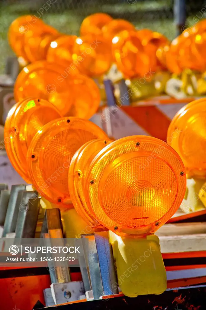 Orange safety warning lights are stacked ready for use at a California industrial worksite.