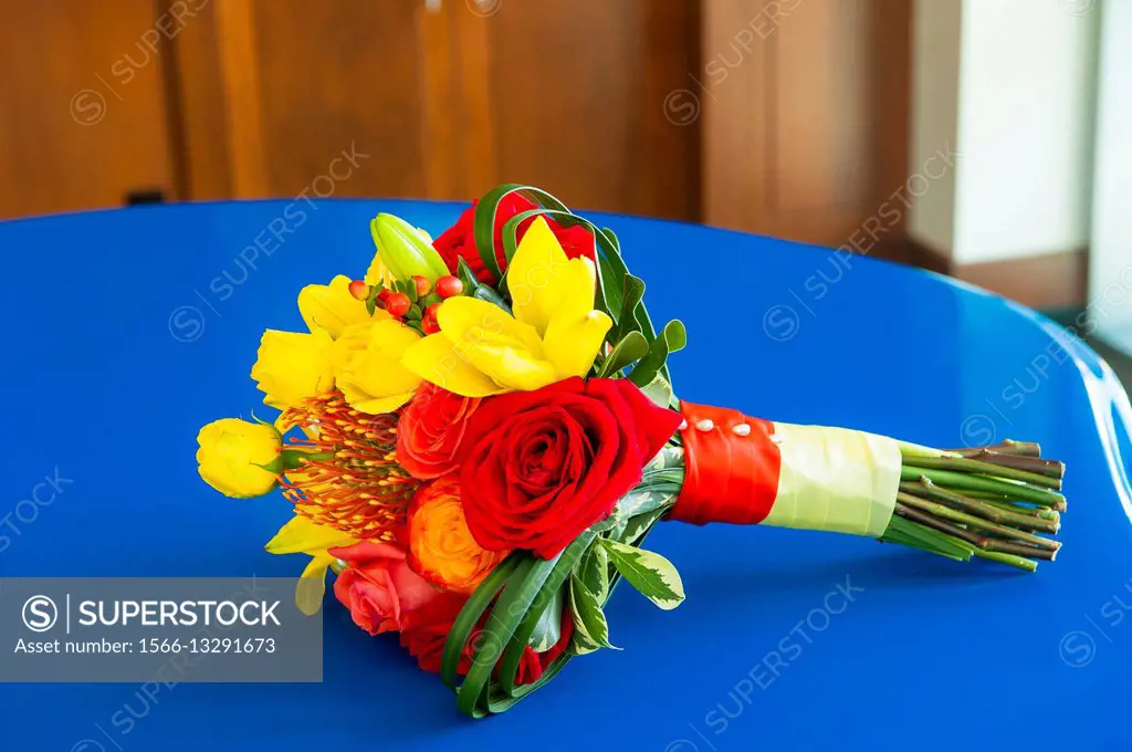 A wedding bouquet of bright flowers on a blue table.