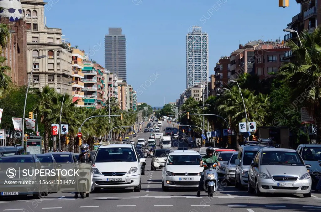 Motorcycles and cars stopped at a stoplight. Traffic. Palms, stoplights. Street View to the horizon, to the sea. Mapfre Tower, Hotel Arts. Barcelona, ...