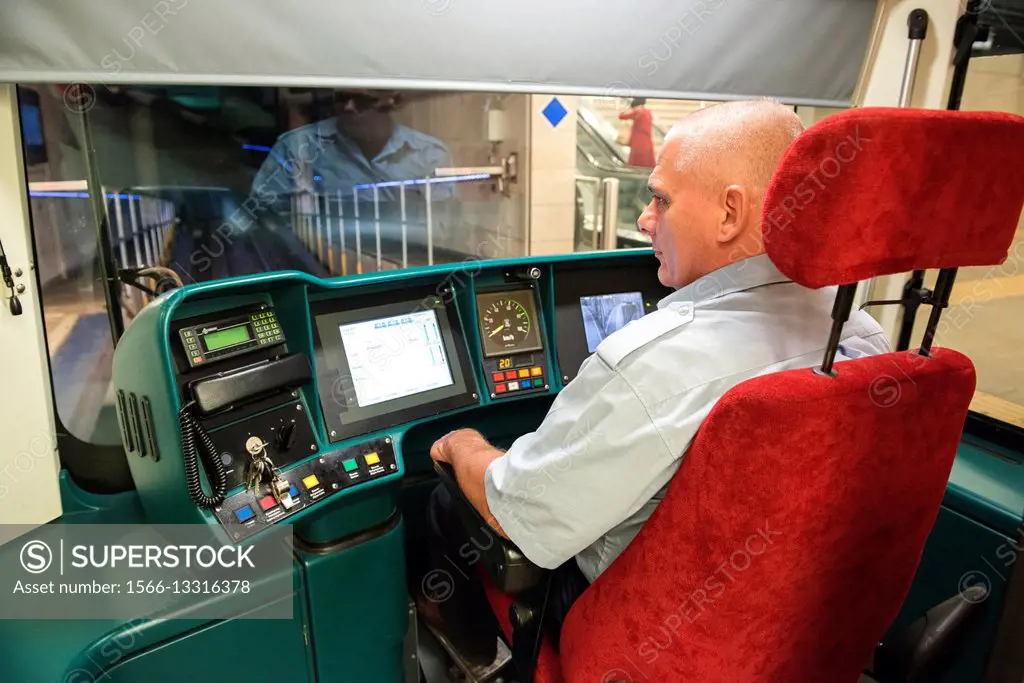 Rotterdam, Netherlands. Underground subway train driver and operator inside the drivers seat and cabin of his subway train.