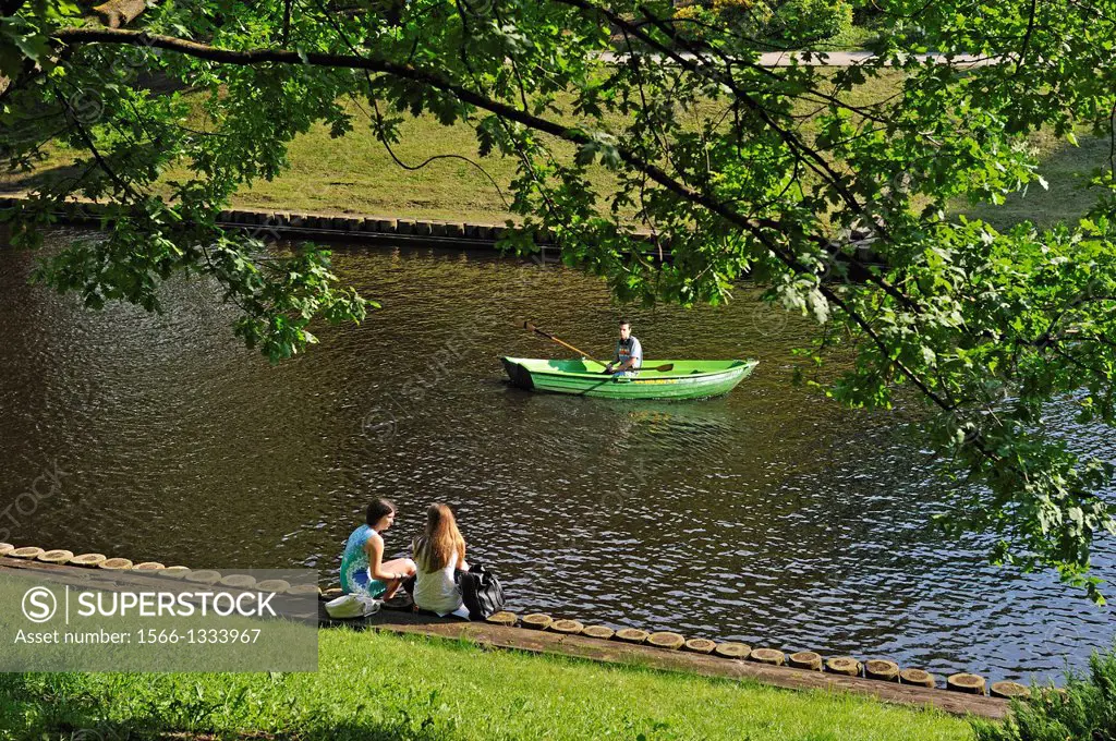 young people on the bank of the Canal surrounding the Old Town of Riga, Latvia, Baltic region, Northern Europe
