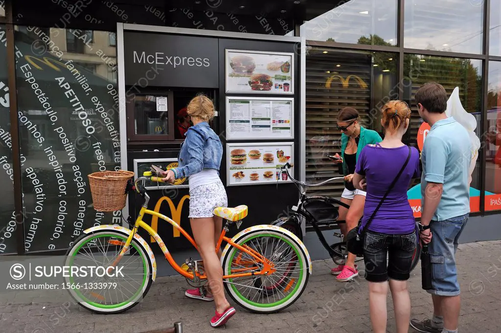 young girl on bike beside a fastfood, Riga, Latvia, Baltic region, Northern Europe