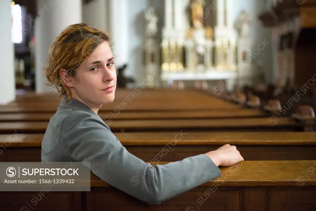 Tilburg, Netherlands. Young woman in the benches of a Roman Catholic Church, after her prayers to the eternal spirit.