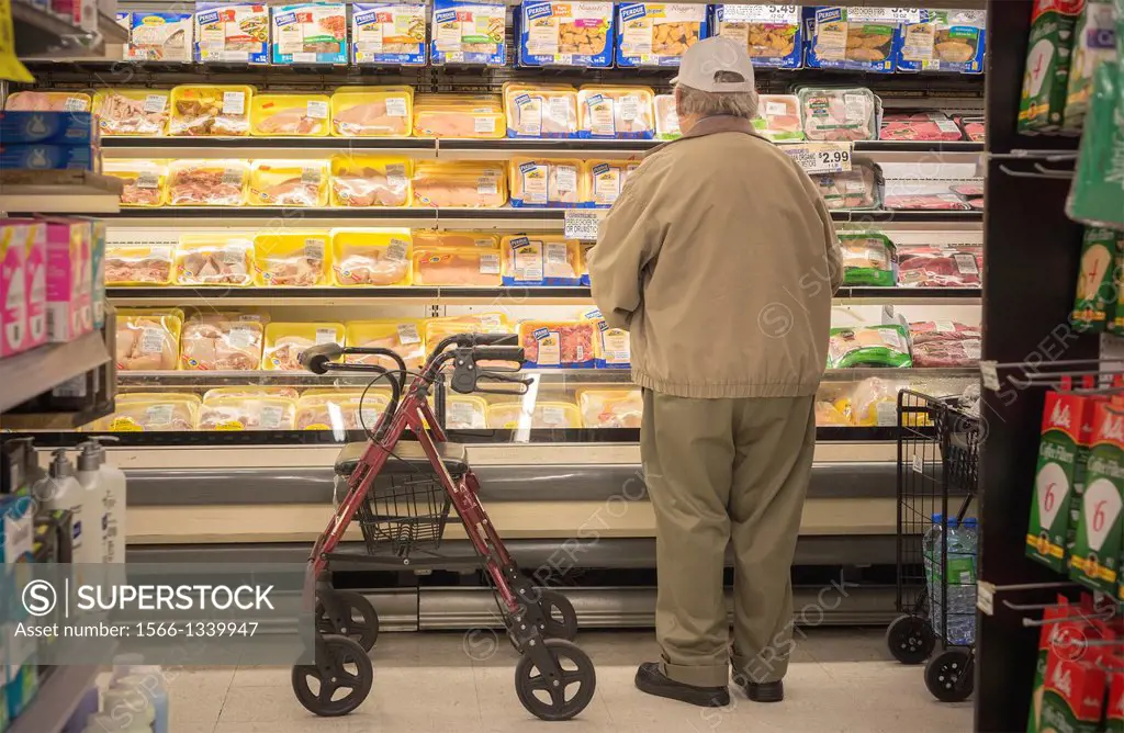 A Senior citizen shops for chicken in the meat department of a supermarket in New York