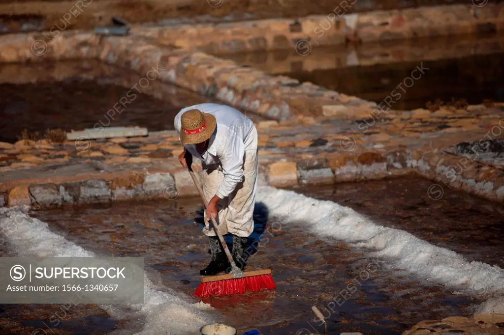 A man cleans a salt flat using a scrub brush at the Salinas de Hortales salt mine in Prado del Rey, Cadiz, Andalusia, Spain, July 16, 2013. Built by t...