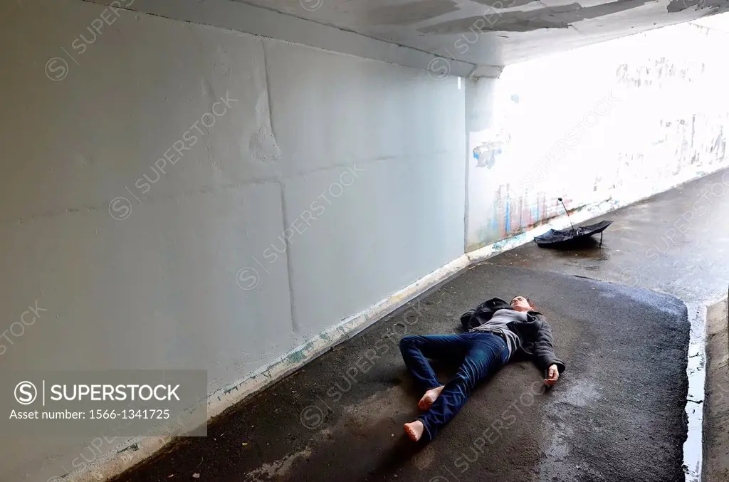 Crime scene concept photo of a murder victim woman lying dead on the ground of a tunnel.