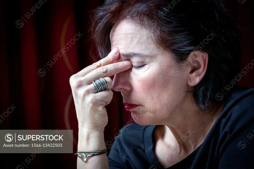 Middle-aged woman´s profile with fingers on forehead, relaxing, meditation