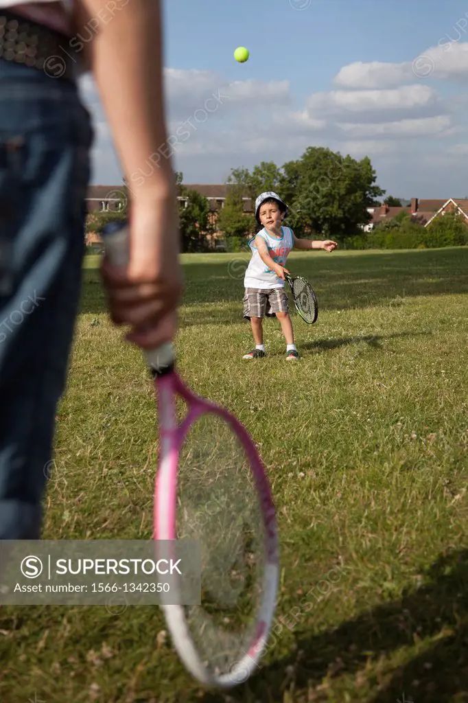 child and parent playing tennis together