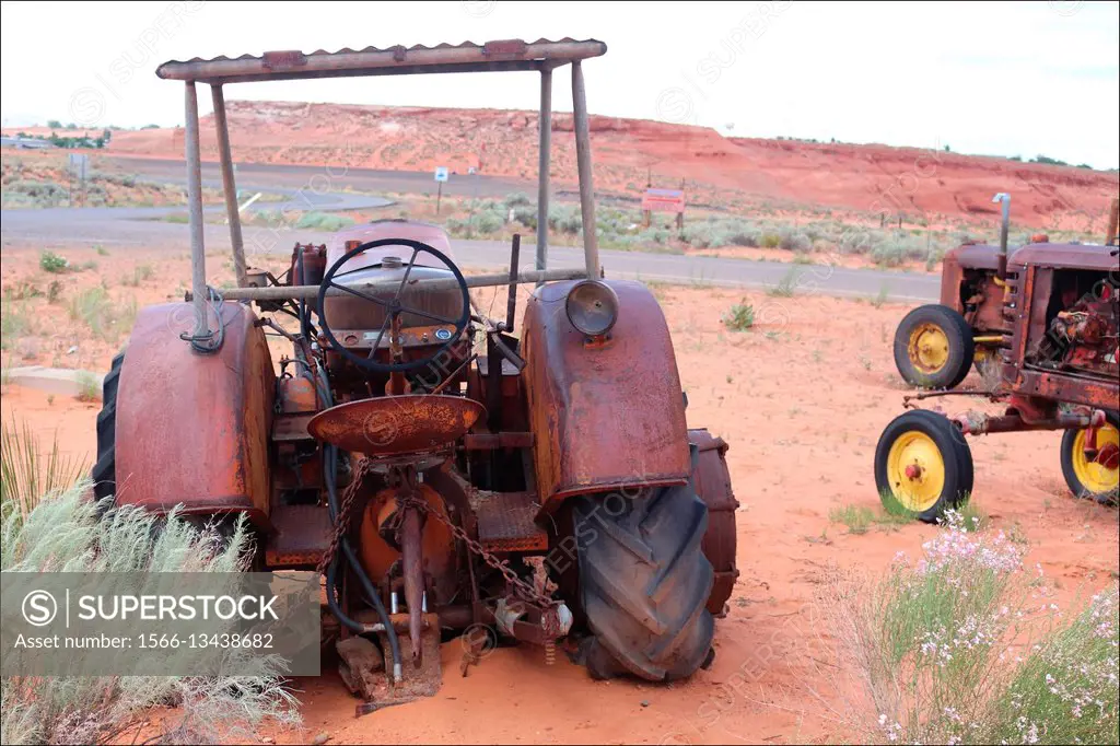 Old tractors rust away under a hot desert sun in Page, Arizona, USA