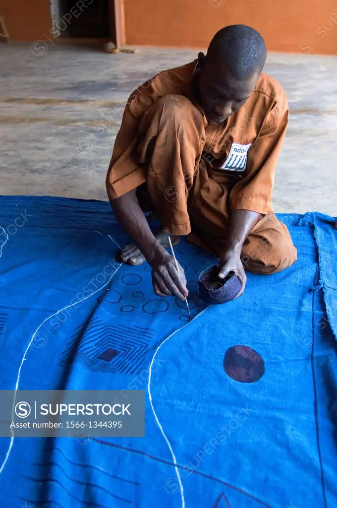 MALI, SEGOU, PRODUCTION OF TRADITIONAL BAMBARA BOGOLAM MUD CLOTH, FABRIC BEING PREPARED FOR DYEING.