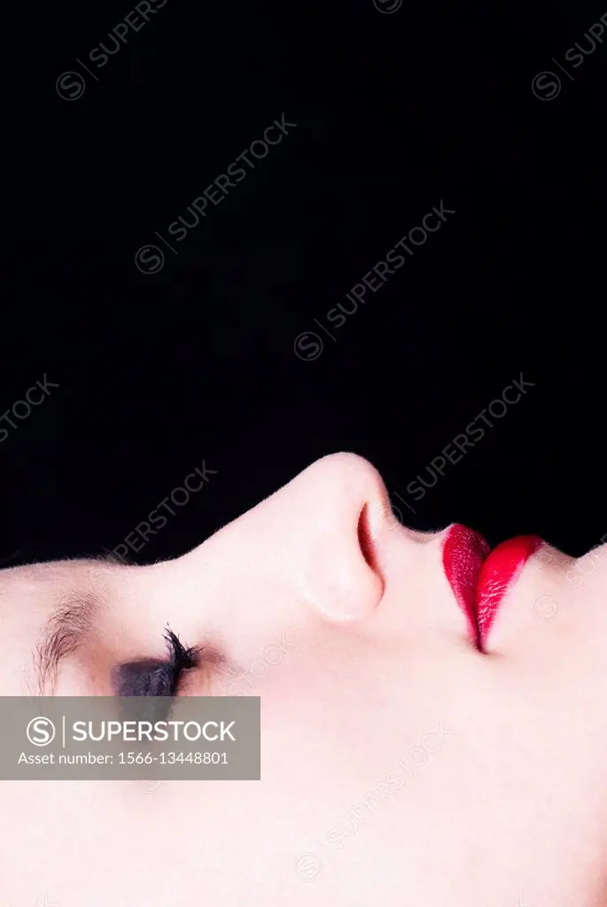 Close up of a woman's face wearing makeup eyes closed.