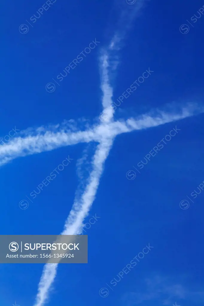 aircraft vapour trails forming a air cross over Berlin, Germany, Europe.