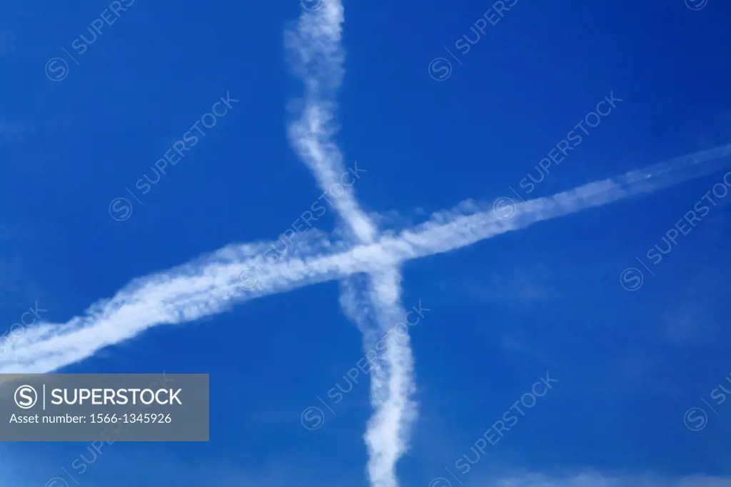 aircraft vapour trails forming a air cross over Berlin, Germany, Europe.