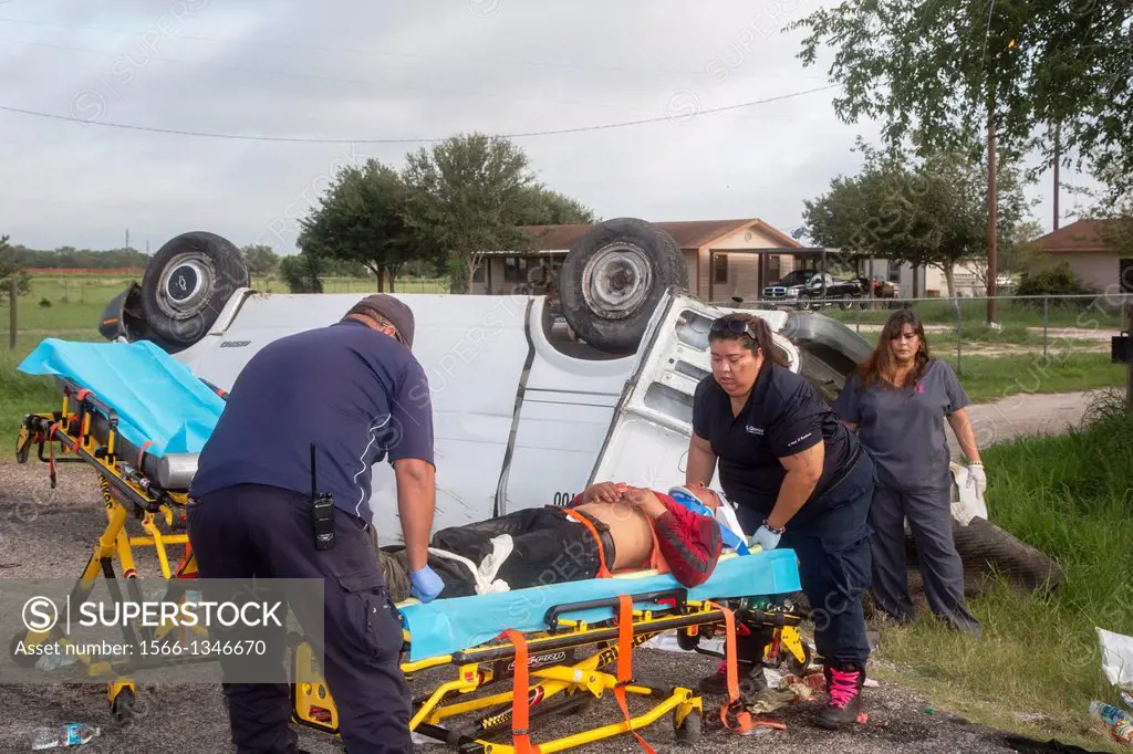 Falfurrias, Texas - EMTs prepare to transport a man injured when an van holding 26 undocumented immigrants from Central America overturned on Texas Hi...