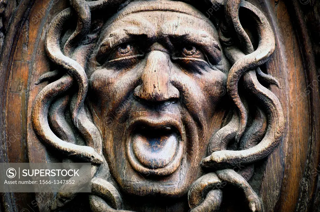 Close up of a face carved on a wooden door in the Marais, Paris, France