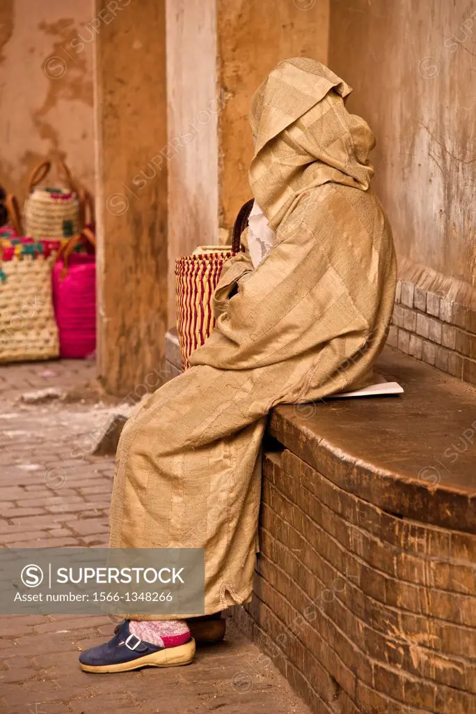 Moroccan woman sitting in the street of the Medina, Marrakech, Morocco.