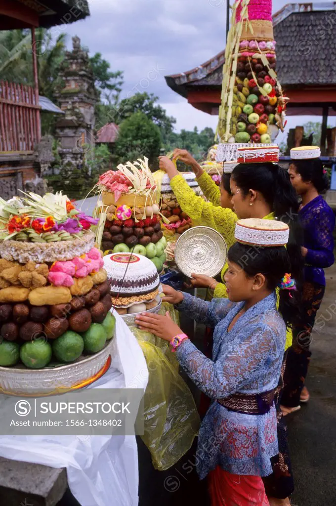 INDONESIA, BALI, SMALL TEMPLE, TEMPLE CEREMONY, MOTHER AND DAUGHTER BRINGING OFFERING.