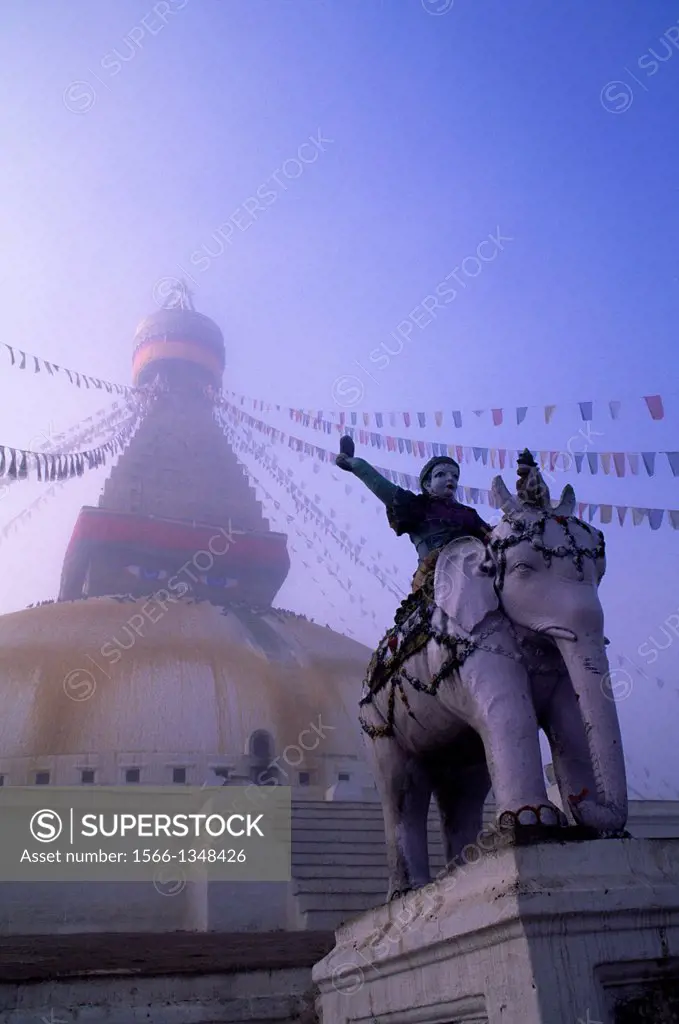 NEPAL, KATHMANDU, BOUDHNATH, TIBETAN STUPA (TEMPLE) IN FOG, PRAYER FLAGS, STATUE.
