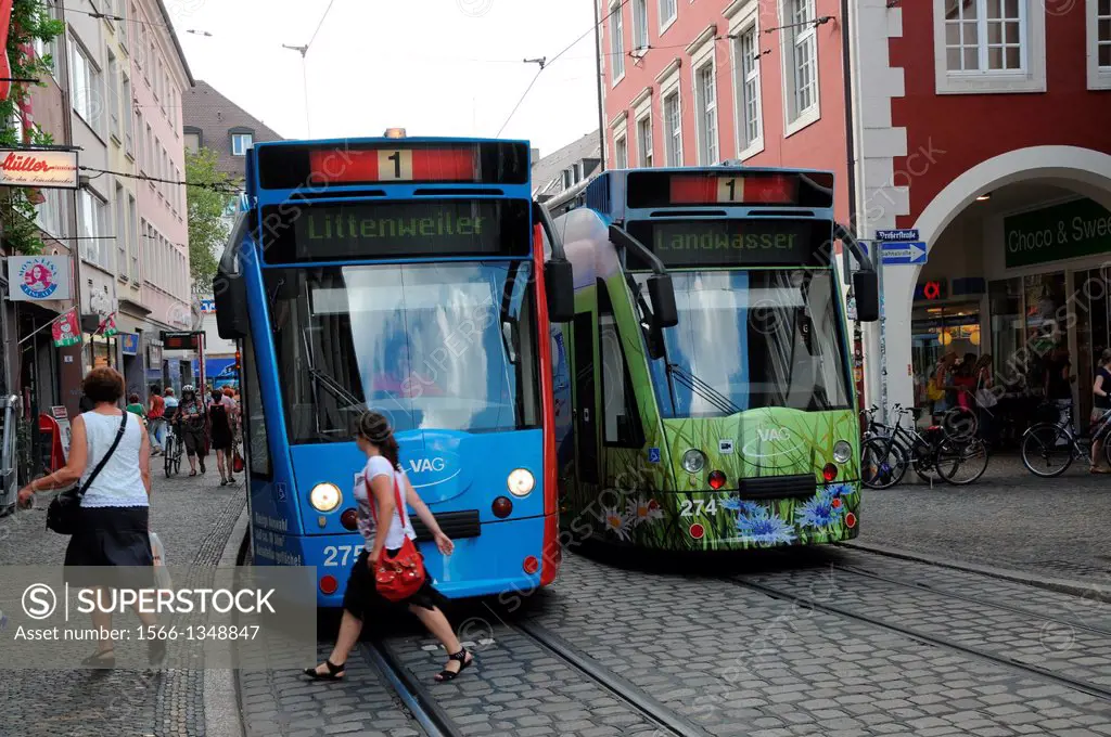 People walk in front of the tram