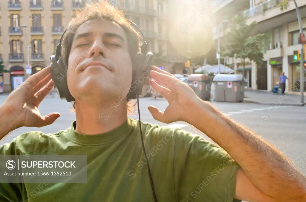 Man listening to music with headphones on a street.