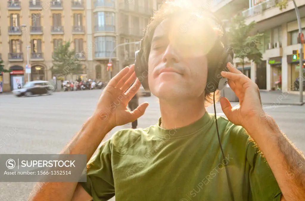 Man listening to music with headphones on a street.