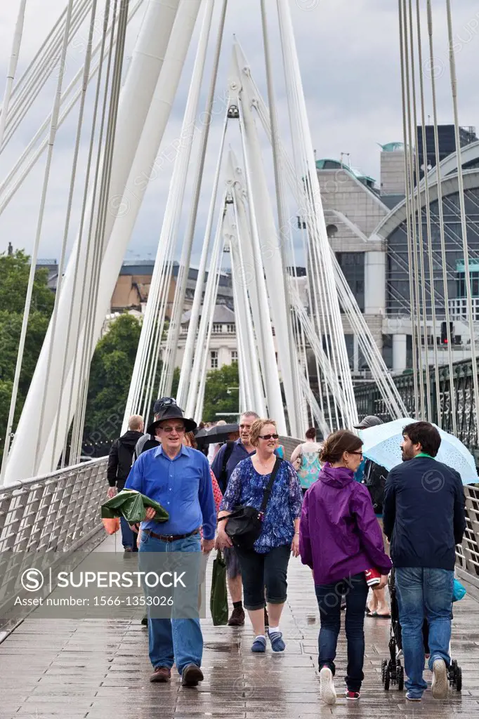 Tourists Crossing The Golden Jubilee Footbridge In The Rain, London, England.