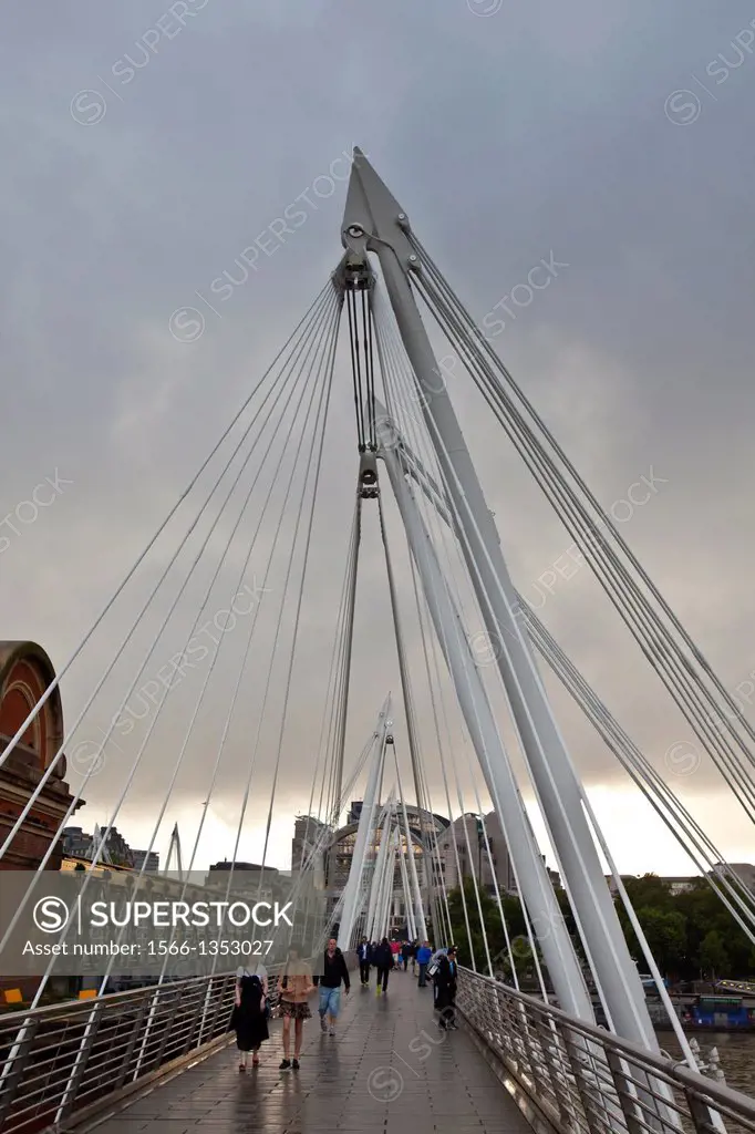 People Crossing The Golden Jubilee Bridge, London, England.