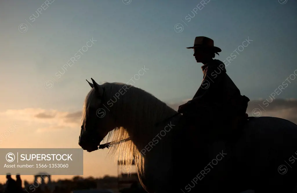 A woman rides a horse during the pilgrimage to the Hermitage of the Virgin of Rocio, in Almonte, Donana National Park, Huelva province, Andalusia, Spa...