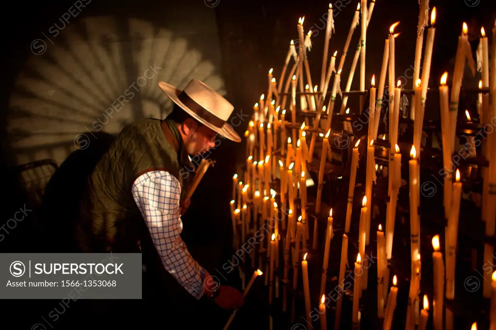 A man, wearing a Spanish hat, lights candles at the Votive Room of the shrine of the Virgin of Rocio, in Almonte, Donana National Park, Huelva provinc...