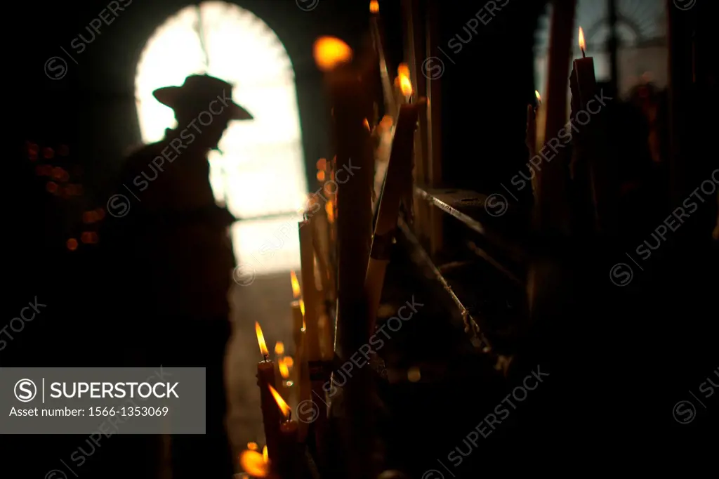 A man lights a candle in the Votive Room of the shrine of the Virgin of Rocio, in Almonte, Donana National Park, Huelva province, Andalusia, Spain, Ma...