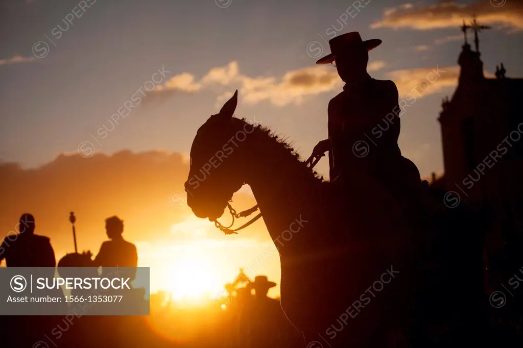 A pilgrim wearing a Spanish hat rides his horse at sunset during the pilgrimagein front of the shrine of the Virgin of Rocio, in Almonte, Donana Natio...