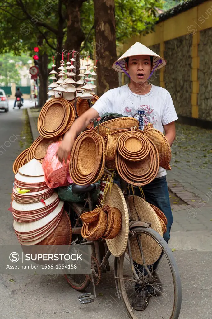 A street vendor selling hats in Hanoi, Vietnam, Asia.