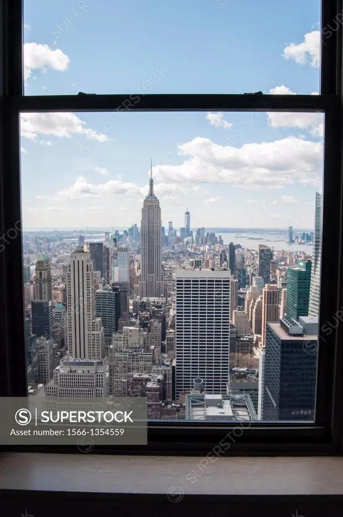 View of the Empire State Building and South Manhattan through a window at the Top of the Rock observation deck, Midtown Manhattan, New York City.