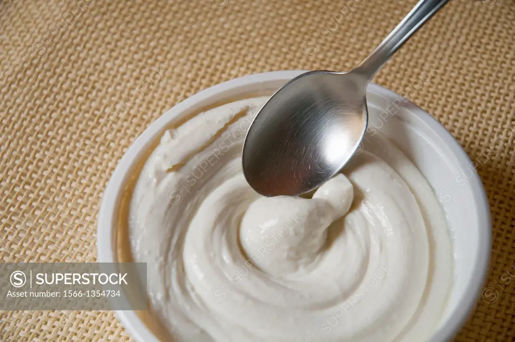 Spoon dipping in a creamy cheese. Close view.