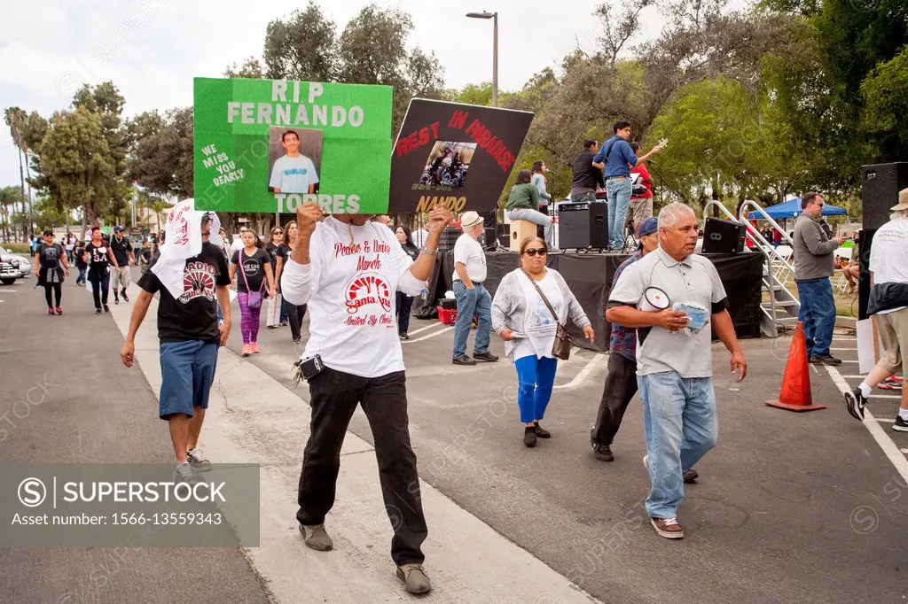 Carrying photos of dead violence victims, local Hispanics march in Santa Ana, CA, city park at a rally against street violence in the community. Note ...