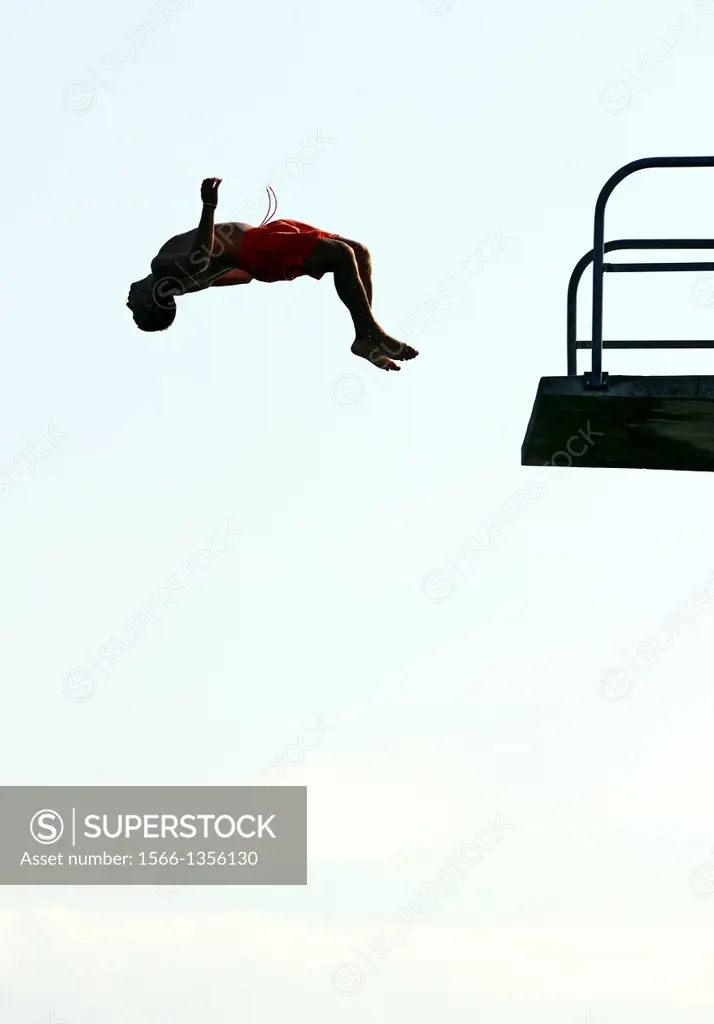 single man jumping from diving tower to waters of Lake Geneva, head first, Paquis beach, Geneva, Switzerland