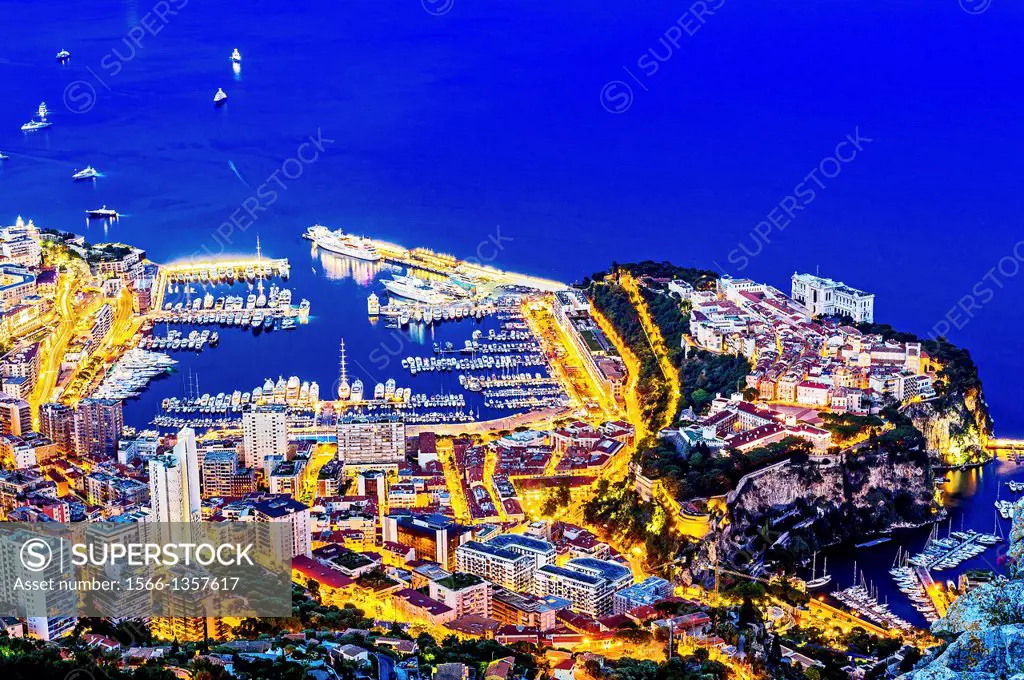 Principality of Monaco, Monte Carlo at night. The rock and the Monaco harbour, port Hercule. Aerial view.
