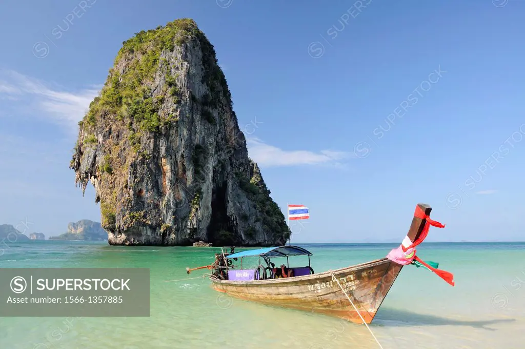 Crystal clear water, long tail boat and limestone karsts viewed from the beautiful Phra Nang Beach in Railay. Thailand, Krabi, Railay, Hat Phra Nang....