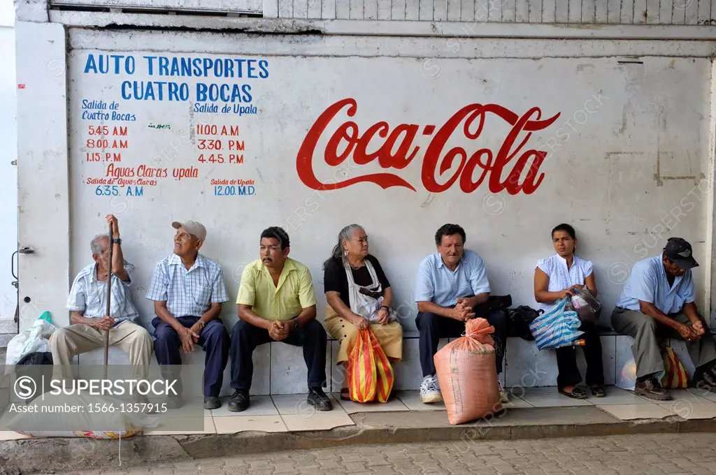 COSTA RICA, TOWN OF UPALA, STREET SCENE, BUS STATION, PEOPLE WAITING FOR BUS, COCA COLA ADVERTISEMENT.1015