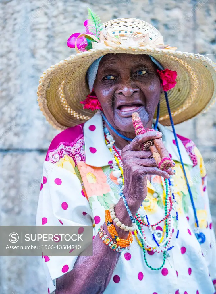 A portrait of a Cuban woman smoking cigar in old Havana street. Cuba now exports more than 90 million cigars a year.