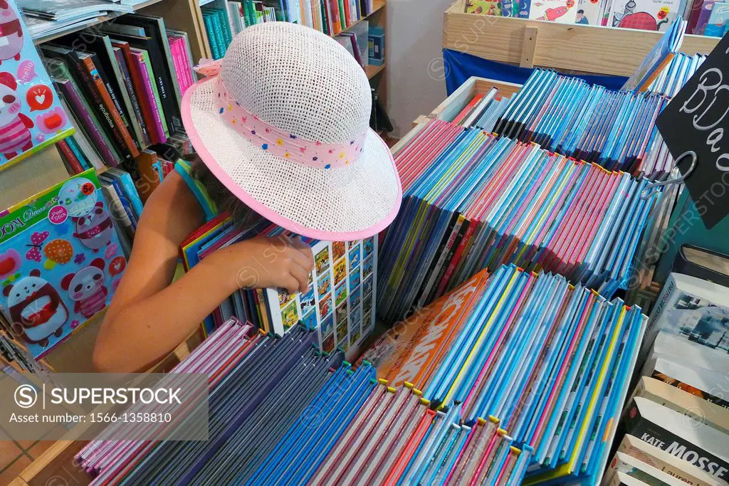A little girl looking for a book to buy.
