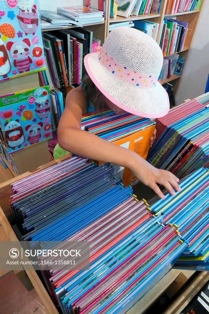 A young girl searches through the children's section of a bookstore.